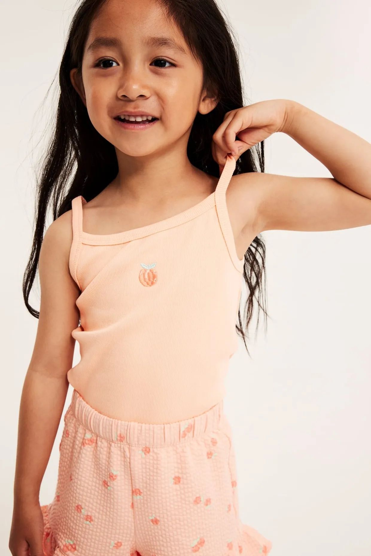 Ribbet singlet med ferskenbroderi