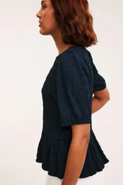 Strukturert topp med peplum og korte ermer